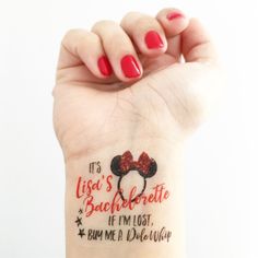 a woman's wrist with a red minnie mouse tattoo on her left arm and the words, it's lise's bachelorette if i'm lost, bum me a disney