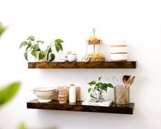 two wooden shelves with plants and candles on them