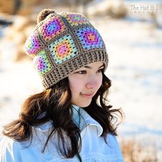 a young woman wearing a crocheted hat in the wintertime with snow on the ground behind her