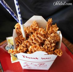 there is noodle noodles in the box on the red tray with two blue and white chopsticks