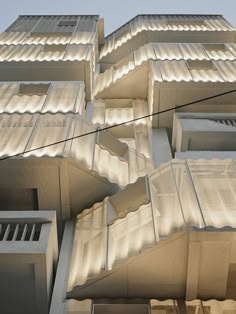 the facade of an apartment building is lit up with light from windows and balconies