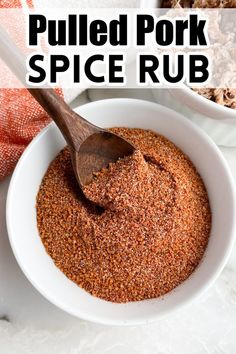 a white bowl filled with spice rub next to a wooden spoon on top of a table