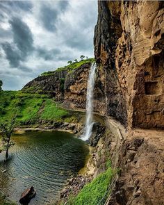 a waterfall is coming out of the side of a cliff