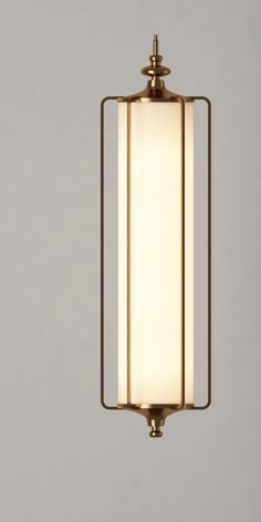 a light hanging from the ceiling with a white glass shade on it's side