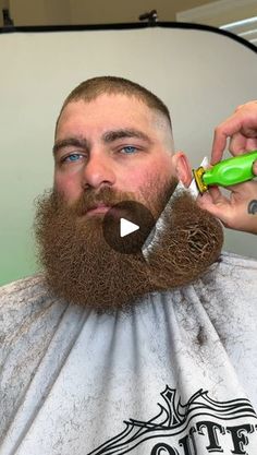 a man is getting his hair cut with an electric trimmer and green toothbrush