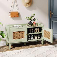 a green cabinet with shoes and purses on it in front of a white rug