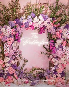 a pink and purple floral wedding arch with the words the peachling room on it