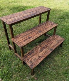 three wooden benches sitting on top of a lush green field