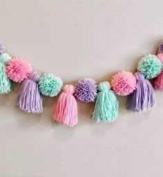 a multicolored tasselled garland with pom - poms hanging from it