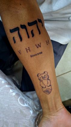 a person with a tattoo on their arm that reads hebrew why? and an image of a teddy bear