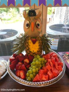 an owl statue sitting on top of a plate of fruit