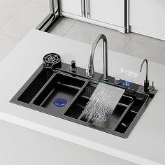 a kitchen sink with two faucets on the side and a drainer in the middle