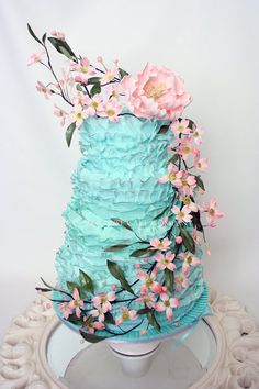 a blue cake with pink flowers on top