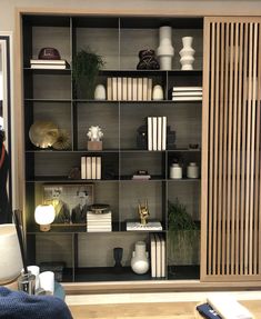 a book shelf filled with books and vases