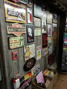 there are many signs on the wall in this room that is covered with wood planks