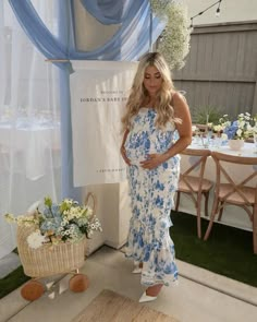 a pregnant woman standing in front of a table