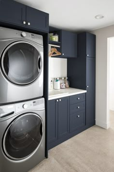 a washer and dryer in a room with blue cabinets on the wall,