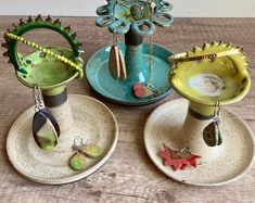 three ceramic vases sitting on top of each other in front of a wooden table