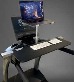 a laptop computer sitting on top of a desk with a keyboard and mouse in front of it