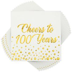 white and gold cheers to 100 years napkins with confetti on the edges