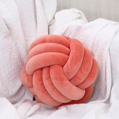 a knoted pillow on top of a white blanket