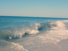 the ocean waves are crashing on the beach