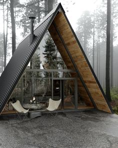 a - frame cabin in the woods with two lounge chairs and a fire pit inside