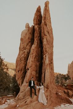 a bride and groom standing in front of large rocks on their wedding day at red rock canyon