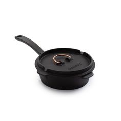 a black pan with a gold handle on a white background