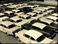 an old photo of many cars parked in a parking lot