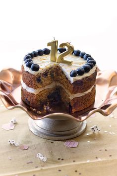 a cake with blueberries and white frosting on a plate