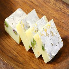 three pieces of cheese sitting on top of a wooden plate