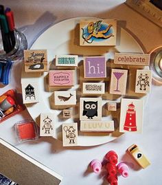 a white plate topped with lots of different types of stamps and magnets on top of a table