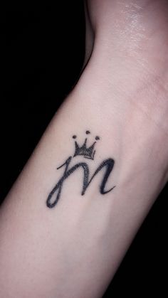 a black and white photo of a wrist tattoo with the letter n on it's side