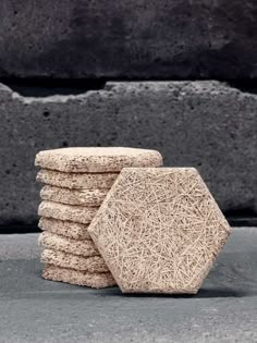 a stack of cookies sitting next to each other on top of a cement slab in front of a concrete wall