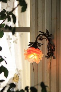 a light that is sitting on the side of a wall next to a window with curtains