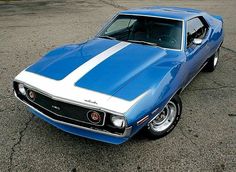 a blue and white muscle car parked in a parking lot