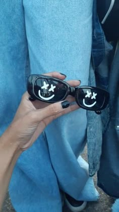 a person holding onto some sunglasses with their hands