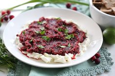 a white plate topped with mashed potatoes and cranberry sauce next to crackers