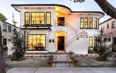 a white house with lots of windows and steps leading up to the front door,