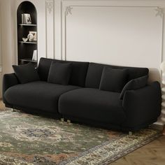 a black couch sitting on top of a rug in a living room