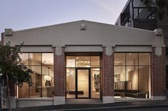 an empty building with glass doors and windows on the outside, in front of a street corner