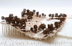 an architectural model of a city with trees on the ground and buildings in the background