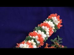 an orange and white flower garland on a blue background