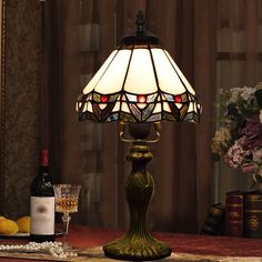 a table lamp sitting on top of a wooden table next to a bottle of wine