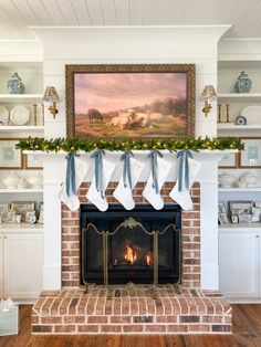 a fireplace decorated for christmas with stockings hanging from the mantel and an image on the mantle