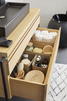 an open drawer in a bathroom filled with toiletries