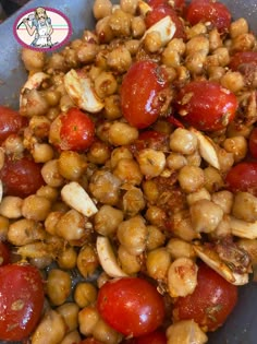 some tomatoes and chickpeas are in a bowl on the stove top, ready to be cooked