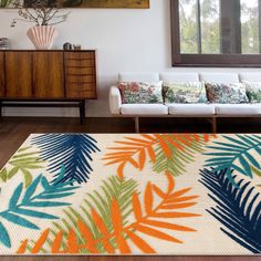 a living room with a white couch and colorful rug