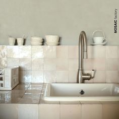 a white sink sitting under a faucet next to a counter top with dishes on it